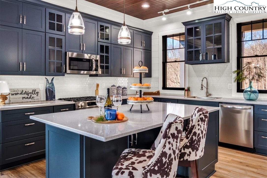 1518 Moxley Ridge Road Independence, VA 24348 - Photo 6 of 50 a kitchen with a sink dishwasher a stove and a refrigerator with wooden floor