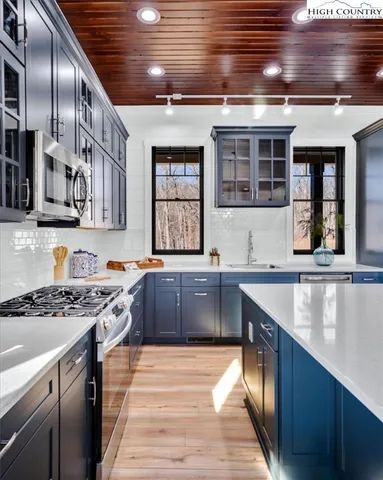 a living room with furniture a table and kitchen view