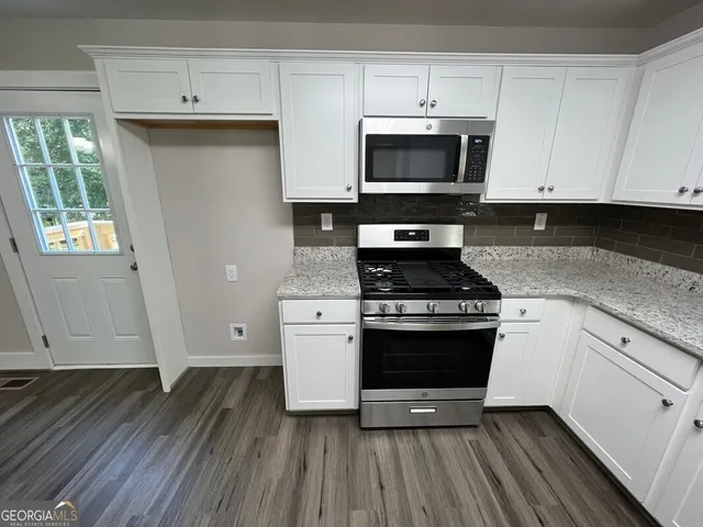 a kitchen with granite countertop a stove and a sink