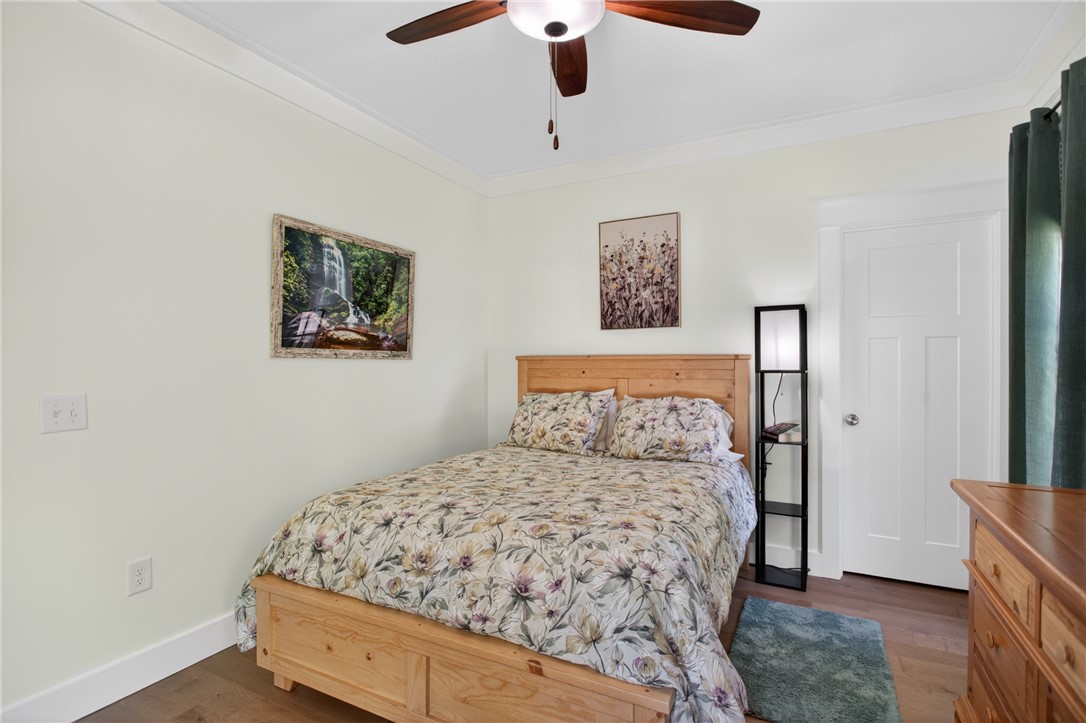 921 Falling Waters Lane Seneca, SC 29672 - Photo 29 of 46 Hardwood floors and a classic wooden bed frame create a serene bedroom retreat.