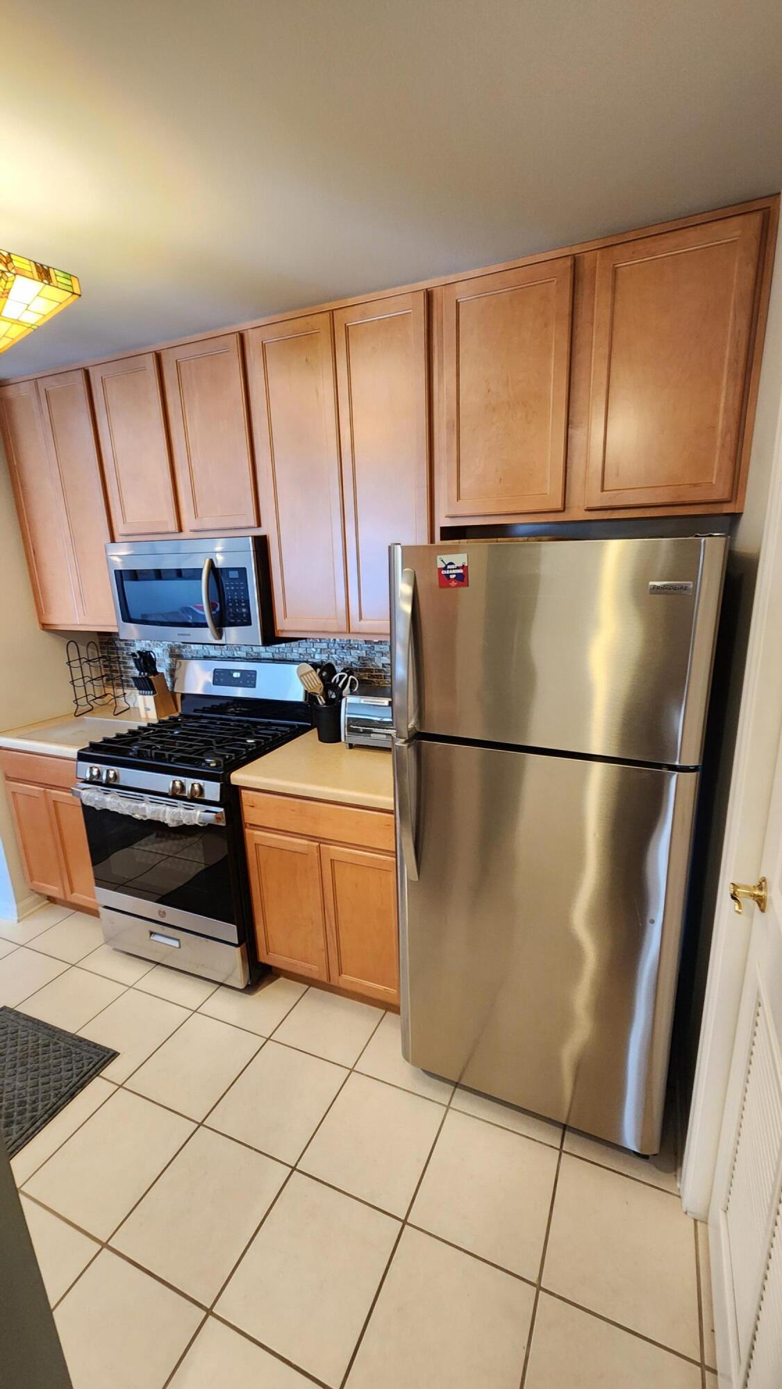 604 Cambridge Court, Unit 2A Munster, IN 46321 - Photo 8 of 31 a kitchen with stainless steel appliances granite countertop a refrigerator a sink a stove a microwave and cabinets