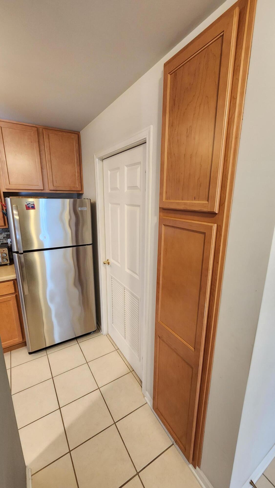 604 Cambridge Court, Unit 2A Munster, IN 46321 - Photo 9 of 31 a view of a refrigerator in kitchen and white wooden cabinets