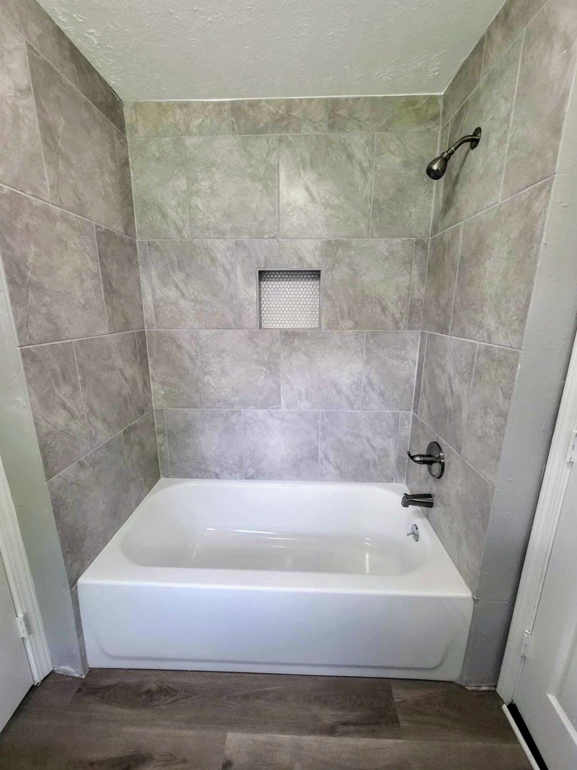 406 East Foley Street Alvin, TX 77511 - Photo 18 of 23 Attractive tub/shower combo with new tile & built in shelf for added storage