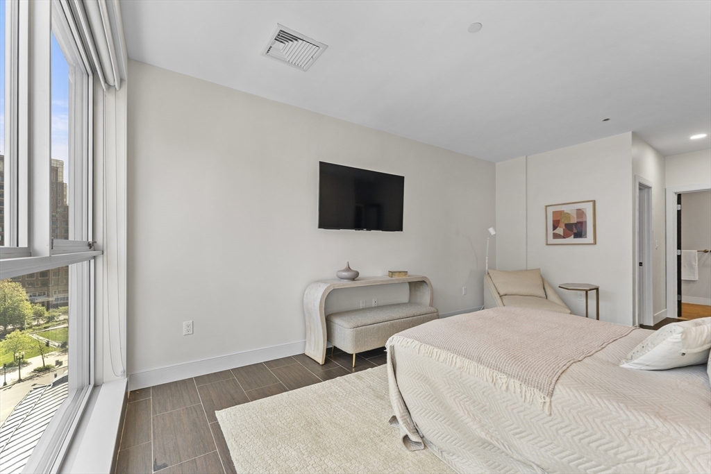 99-105 Broad Street, Unit 8B Boston, MA 02110 - Photo 18 of 37 a bedroom with a bed and a flat screen tv