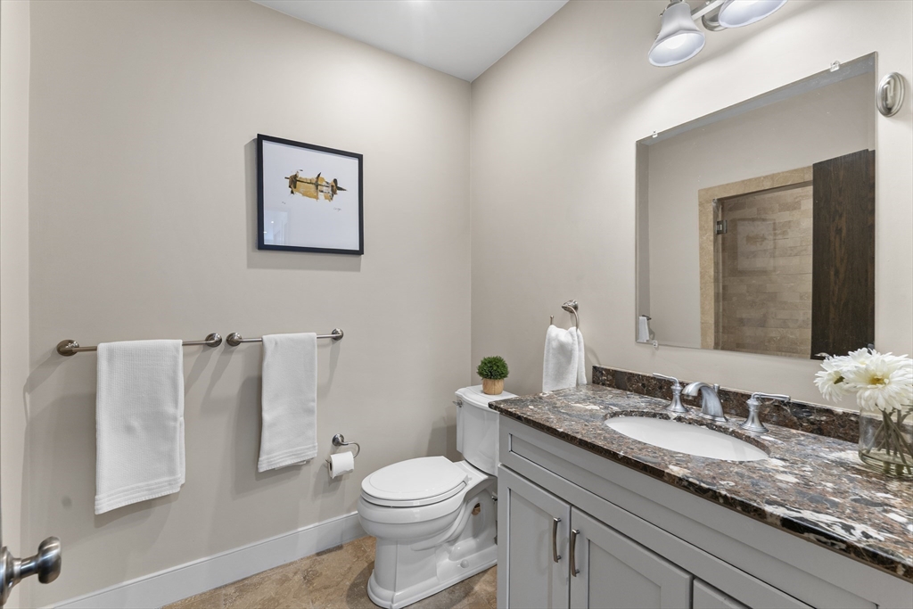99-105 Broad Street, Unit 8B Boston, MA 02110 - Photo 21 of 37 a bathroom with a granite countertop sink and a toilet