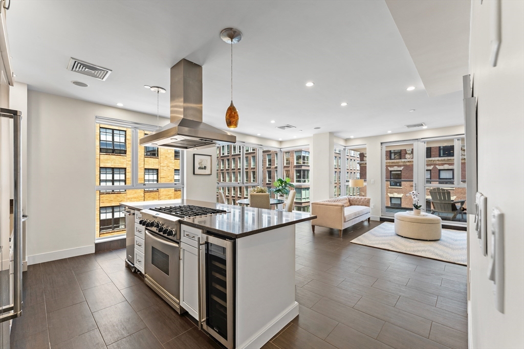 99-105 Broad Street, Unit 8B Boston, MA 02110 - Photo 3 of 37 a open kitchen with stainless steel appliances granite countertop a stove and a large window