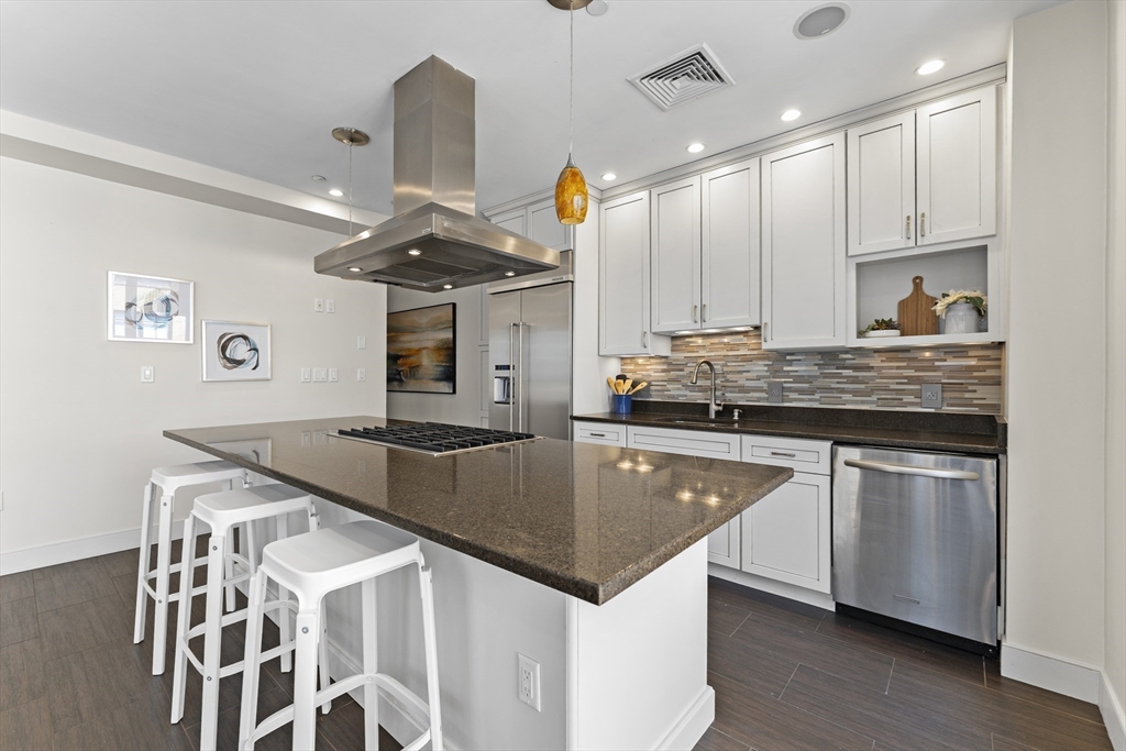 99-105 Broad Street, Unit 8B Boston, MA 02110 - Photo 5 of 37 a kitchen with stainless steel appliances granite countertop a sink a stove and a wooden floors