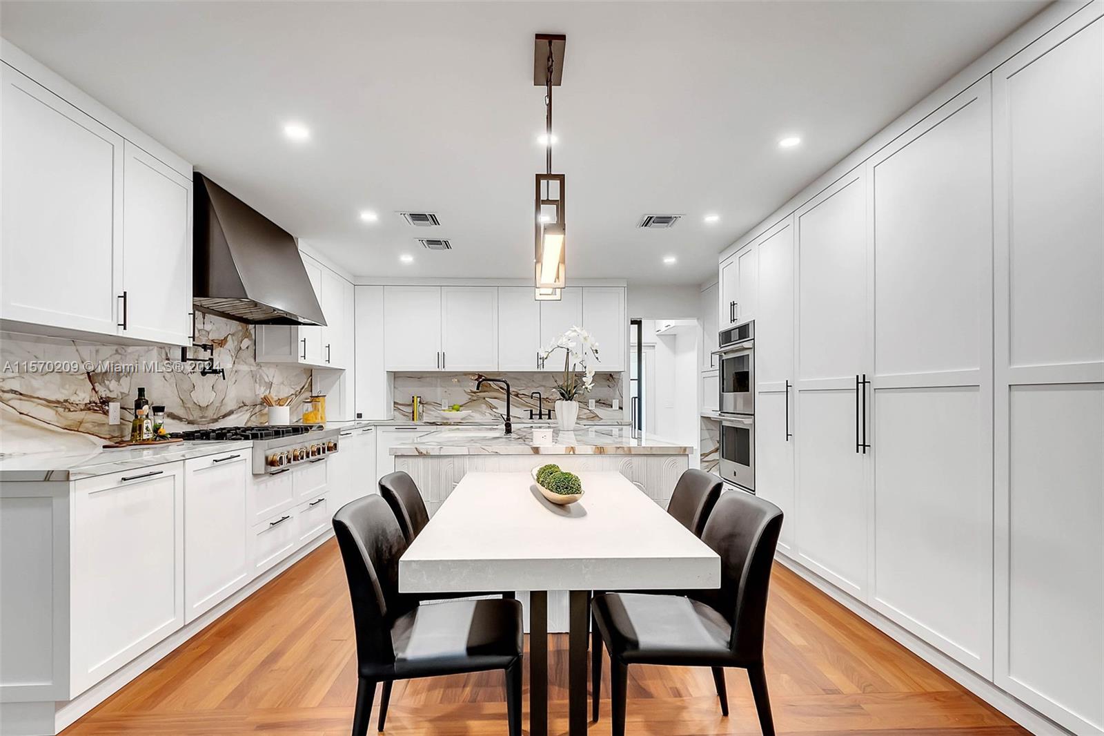 3620 Curtis Lane Miami, FL 33133 - Photo 5 of 33 a kitchen with stainless steel appliances granite countertop a stove a sink a kitchen island with a dining table and chairs