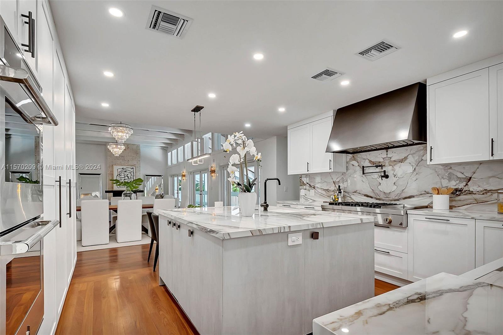 3620 Curtis Lane Miami, FL 33133 - Photo 6 of 33 a kitchen with stainless steel appliances kitchen island granite countertop a sink and cabinets