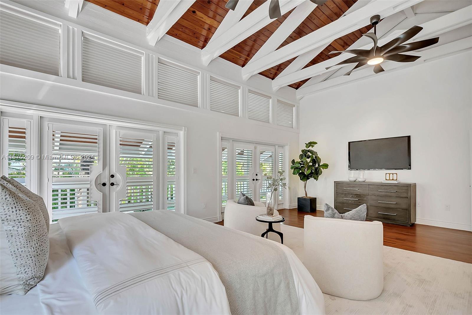 3620 Curtis Lane Miami, FL 33133 - Photo 9 of 33 a bedroom with a large bed a flat screen tv and a fireplace