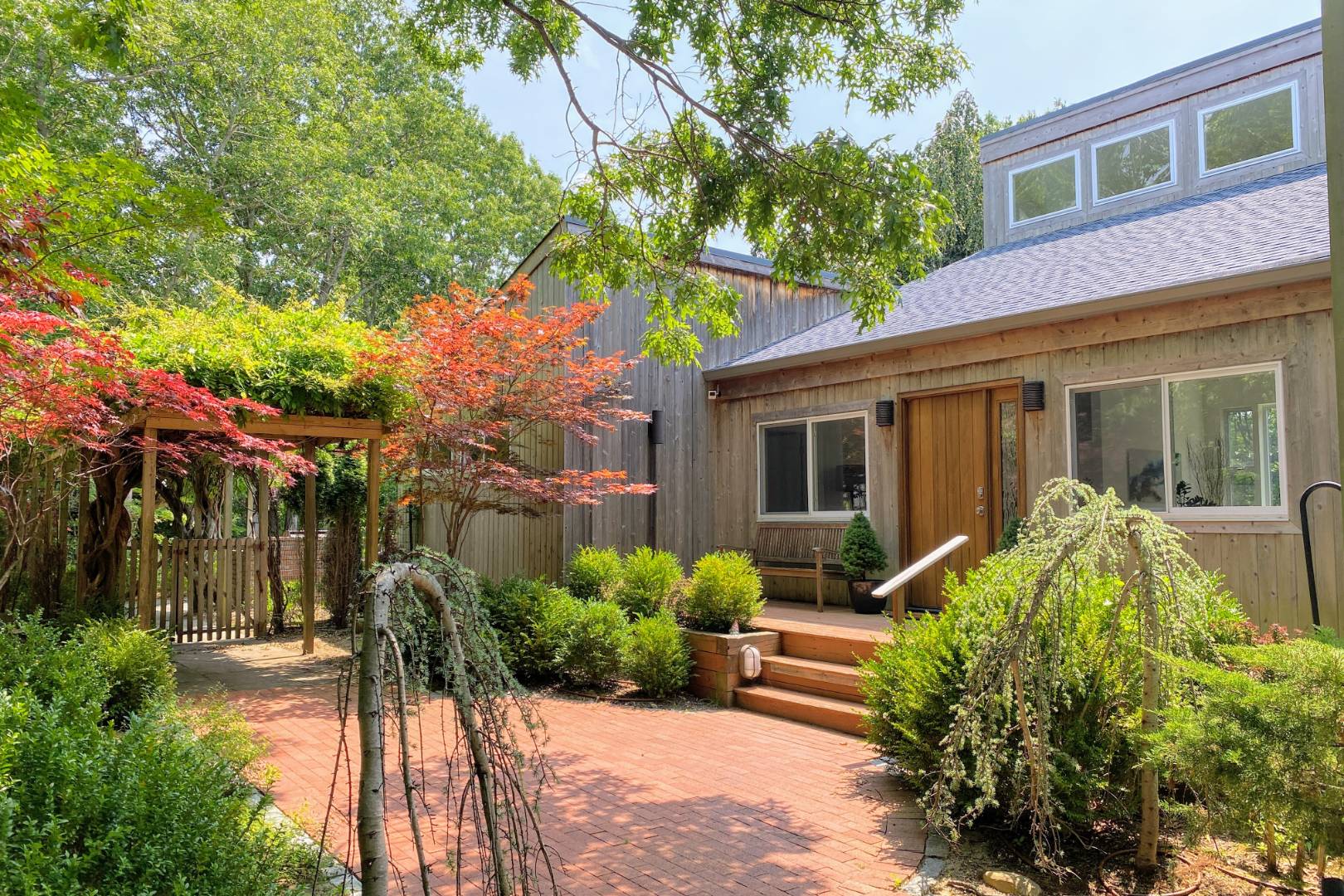 a front view of a house with a yard and potted plants