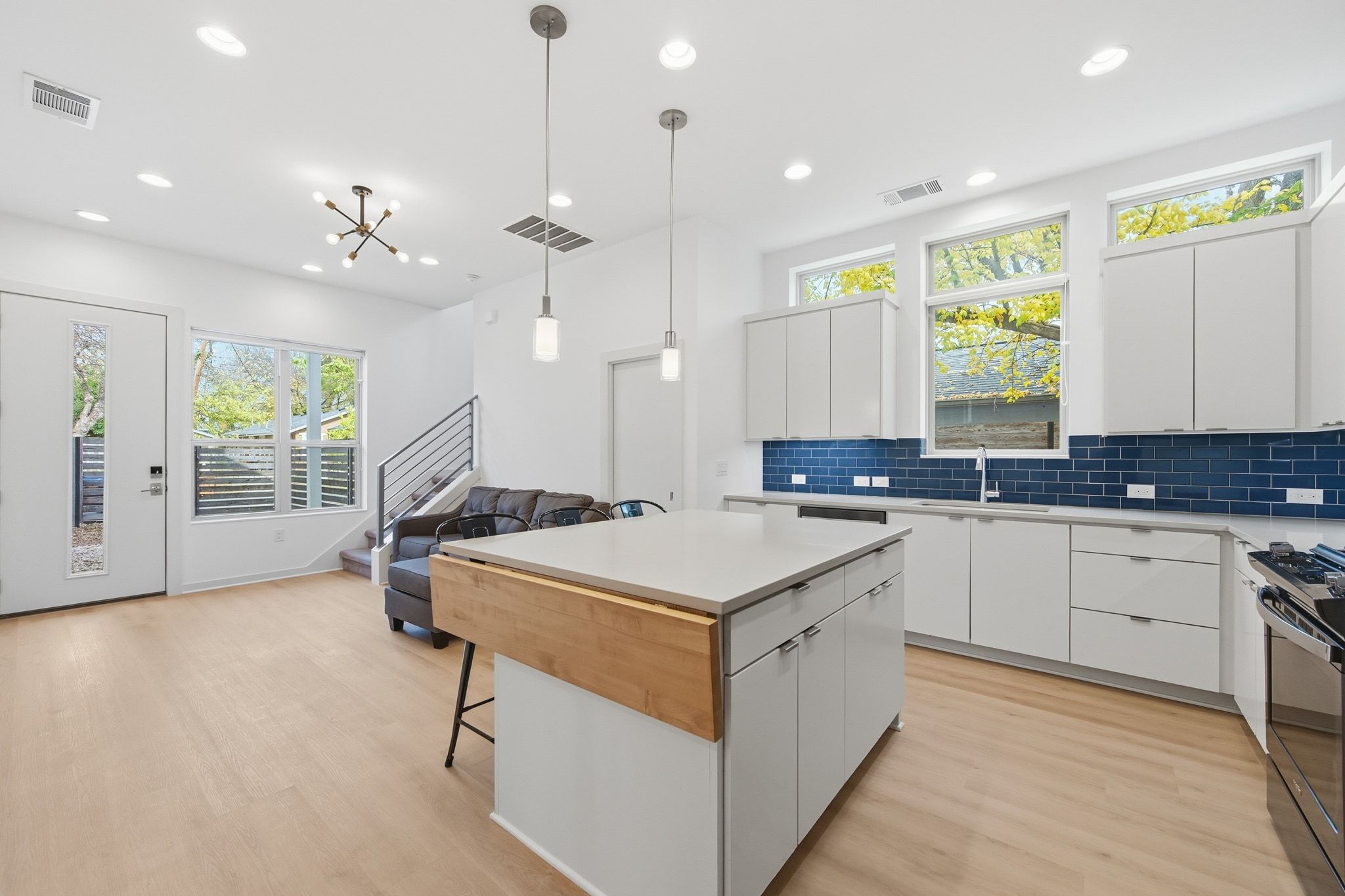 a kitchen with a stove a sink a window and chairs