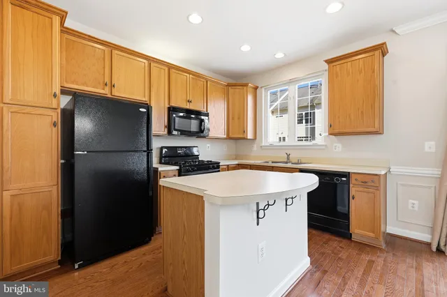 a kitchen with a sink a refrigerator a cabinets and wooden floor