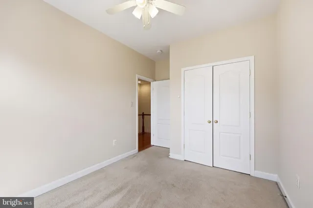 a view of an empty room with a chandelier fan