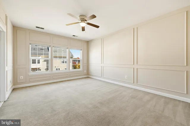 an empty room with chandelier fan