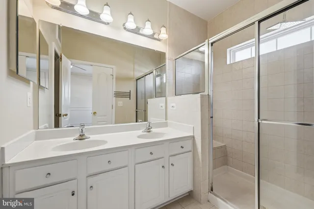 a bathroom with a double vanity sink mirror and shower