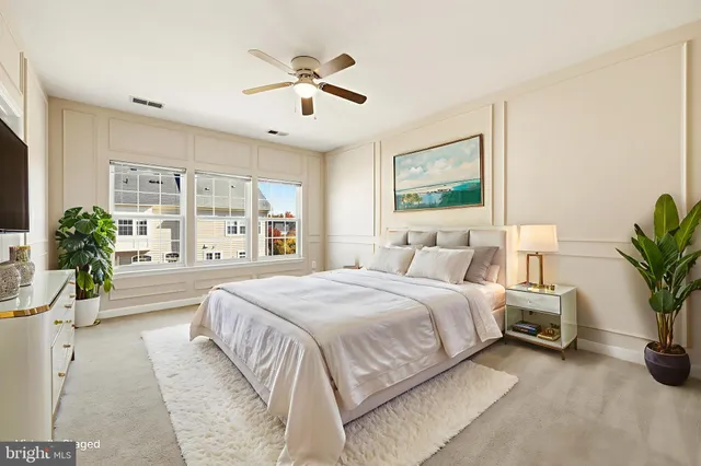 a spacious bedroom with a large bed and a chandelier