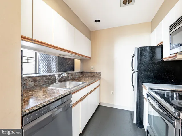 a kitchen with granite countertop a sink and a stove top oven