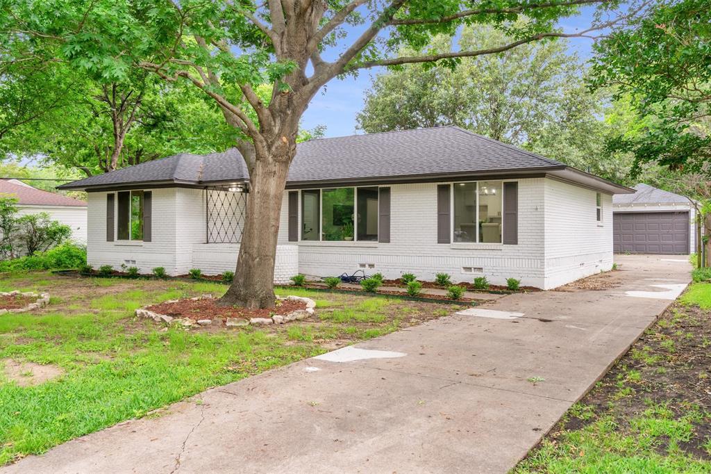 4815 Kelman Street Dallas, TX 75214 - Photo 31 of 37 White brick exterior with dark gray shutters and a dark shingled roof