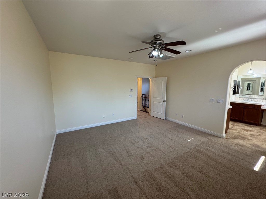 1333 Jamesbury Road Las Vegas, NV 89135 - Photo 31 of 43 Step into a spacious primary bedroom with plush carpeting and an adjoining vanity area.