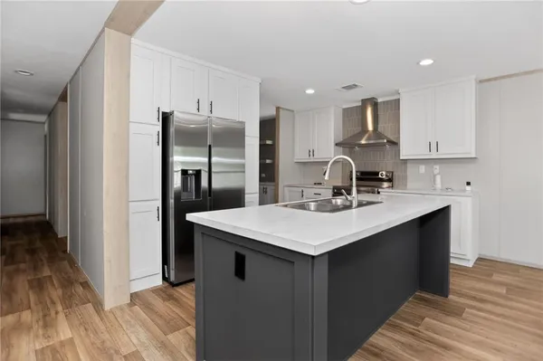 a kitchen with stainless steel appliances a sink stove refrigerator and cabinets