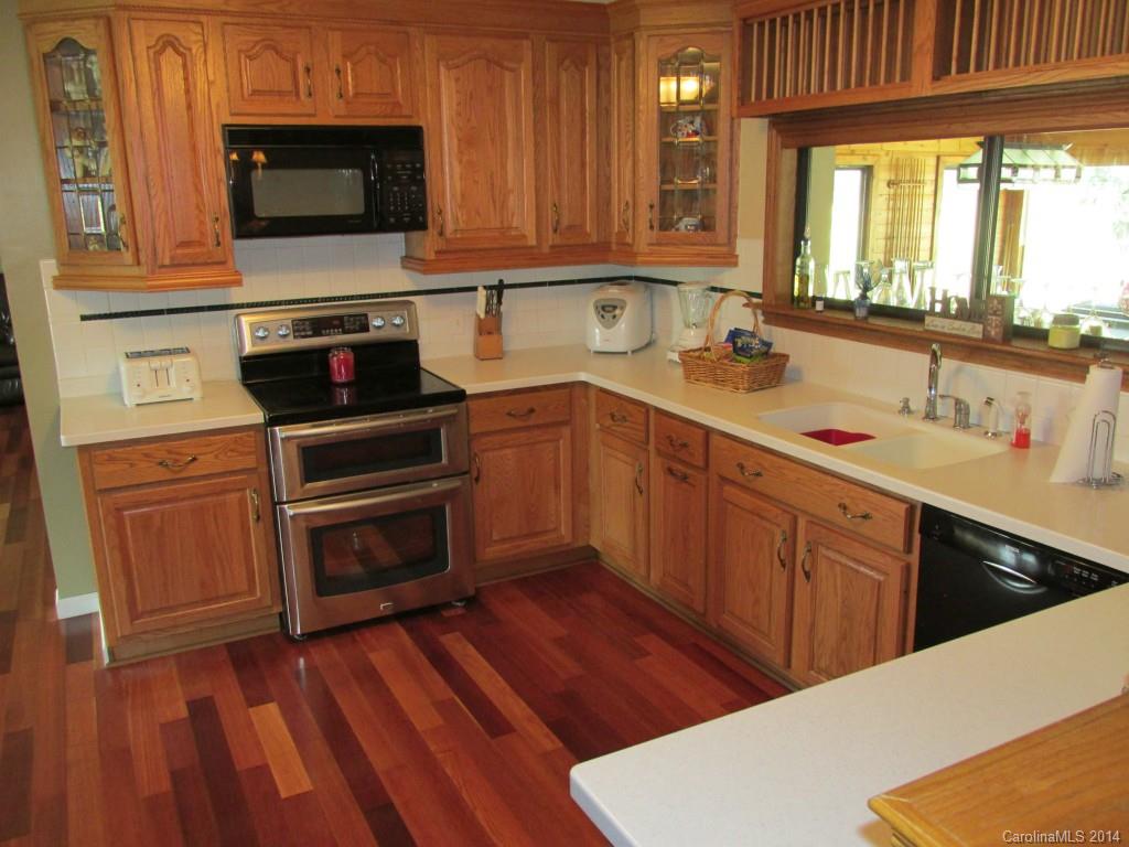 902 Tomberlin Road Monroe, NC 28110 - Photo 6 of 21 a kitchen with a sink wooden floor and a stove top oven
