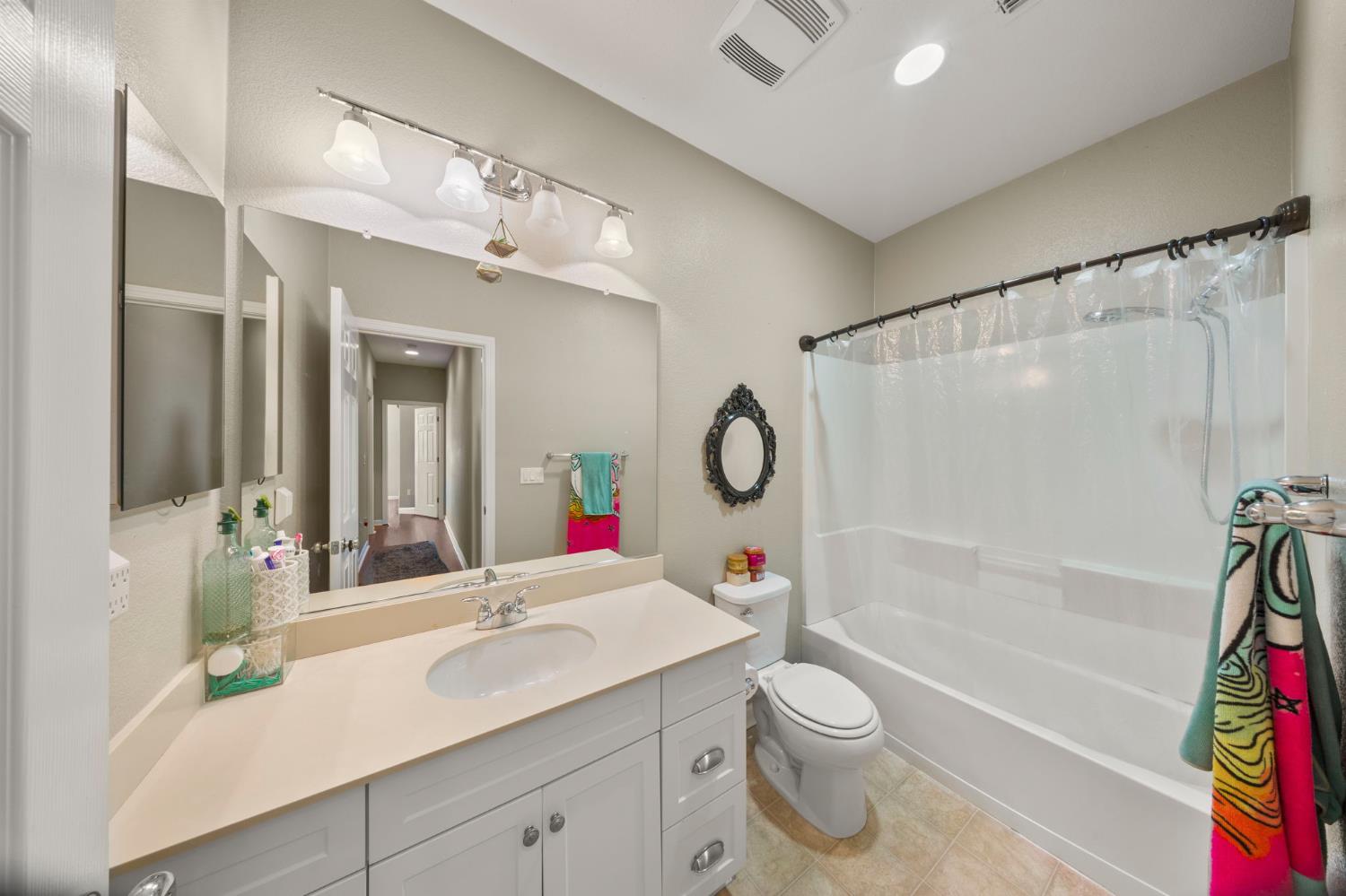 2685 Remy Javier Street Tracy, CA 95377 - Photo 13 of 26 a bathroom with a sink a toilet and a large mirror
