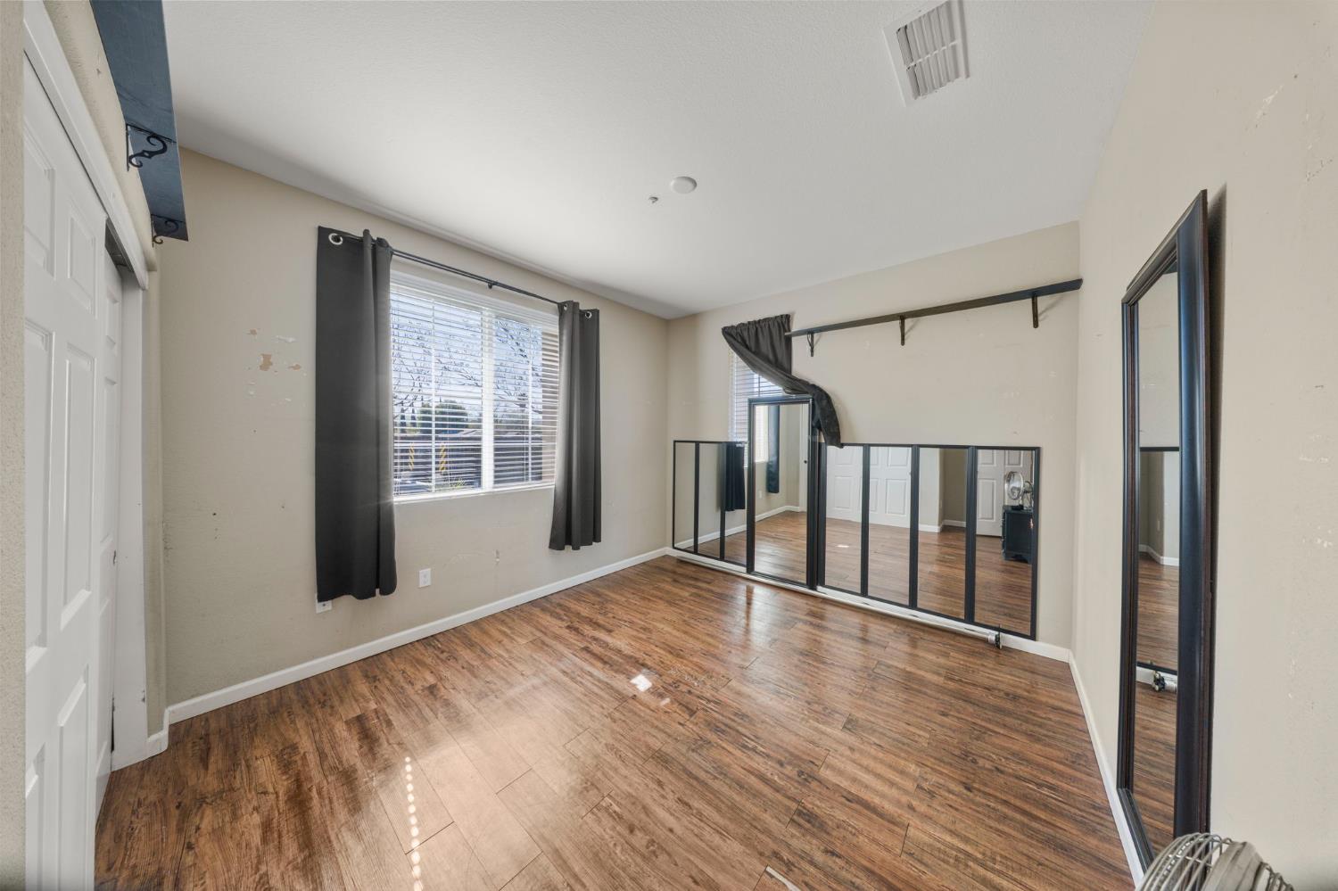 2685 Remy Javier Street Tracy, CA 95377 - Photo 16 of 26 a view of an empty room with wooden floor and a window