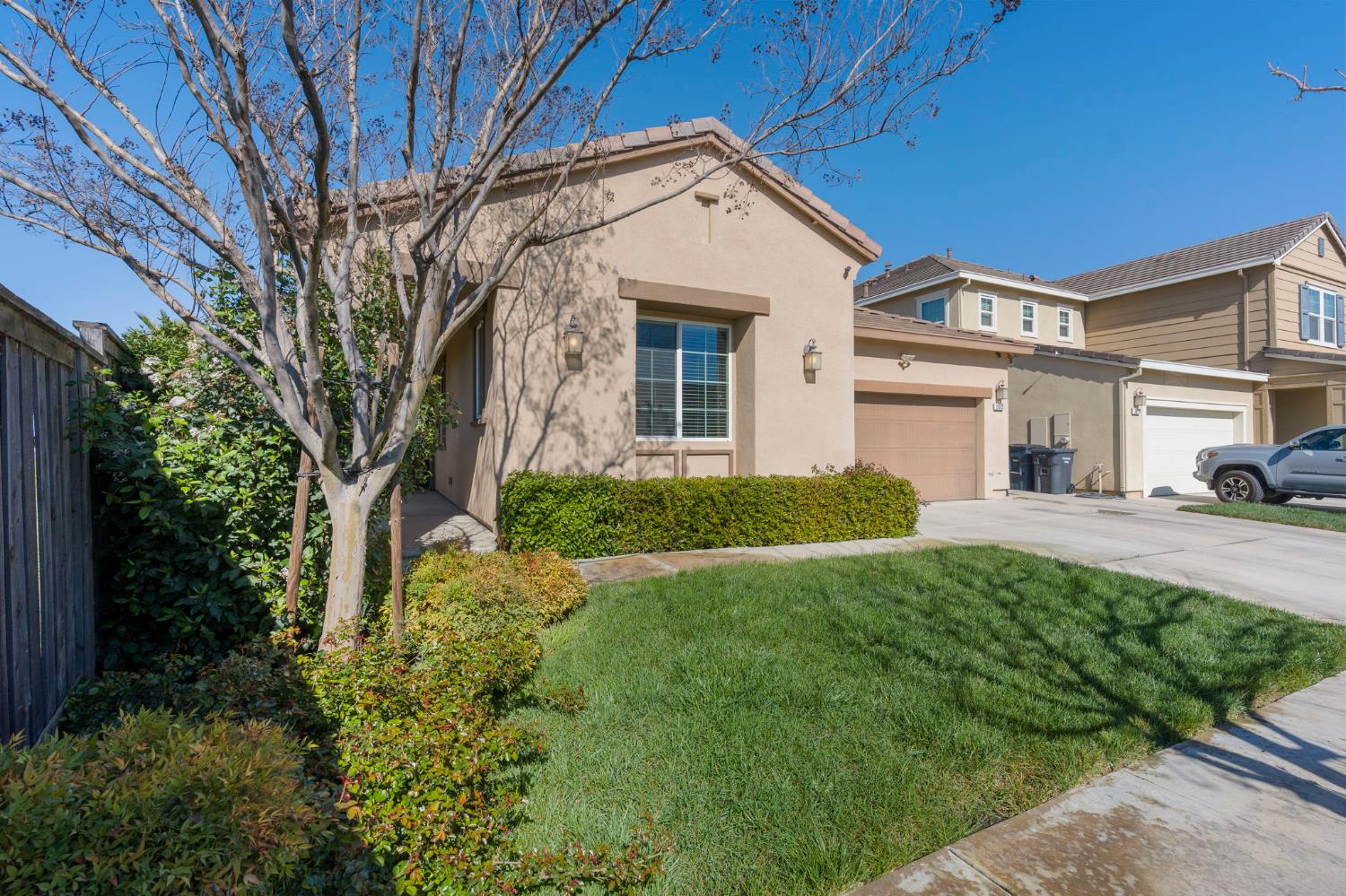 2685 Remy Javier Street Tracy, CA 95377 - Photo 3 of 26 a view of a white house next to a yard with plants and trees