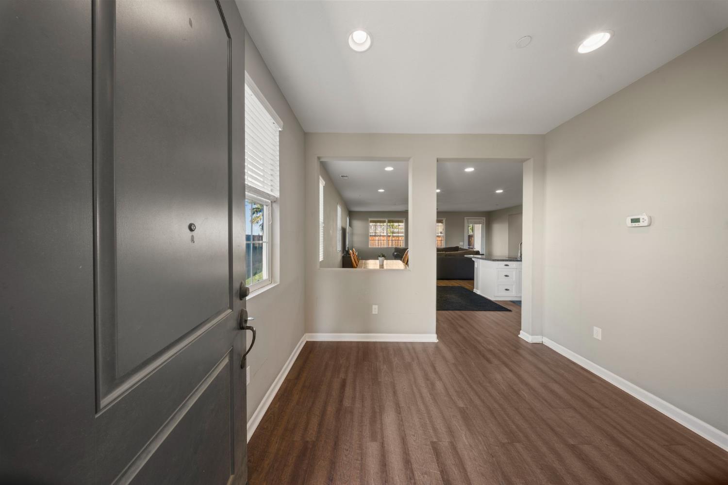 2685 Remy Javier Street Tracy, CA 95377 - Photo 5 of 26 a view of a hallway with wooden floor and a kitchen
