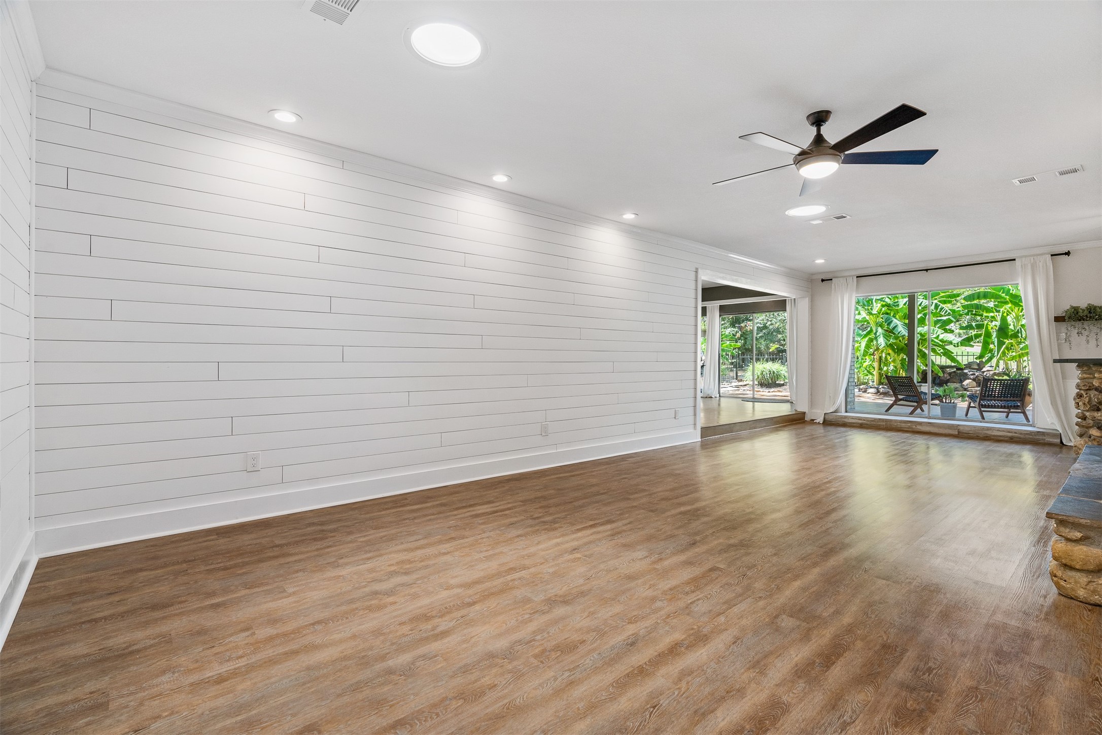 3219 Chippers Crossing Montgomery, TX 77356 - Photo 13 of 35 an empty room with wooden floor and windows with ceiling fan