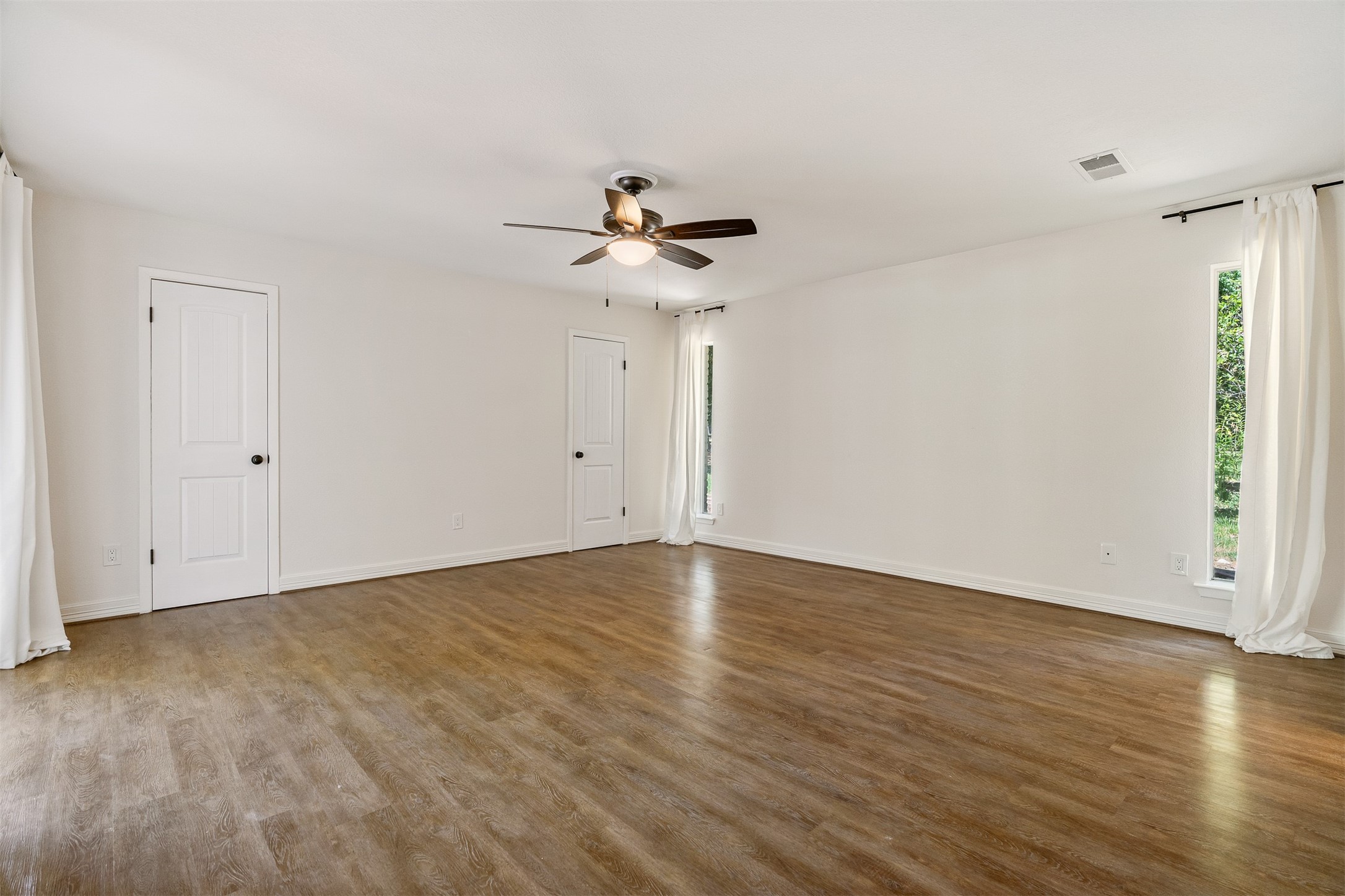 3219 Chippers Crossing Montgomery, TX 77356 - Photo 17 of 35 a view of an empty room with wooden floor and a ceiling fan