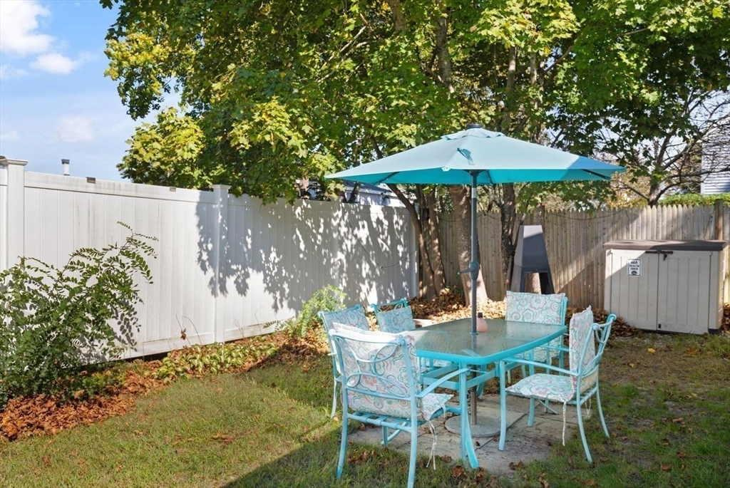 66 Bayview Street Wareham, MA 02571 - Photo 11 of 37 a patio with a table and chairs under an umbrella