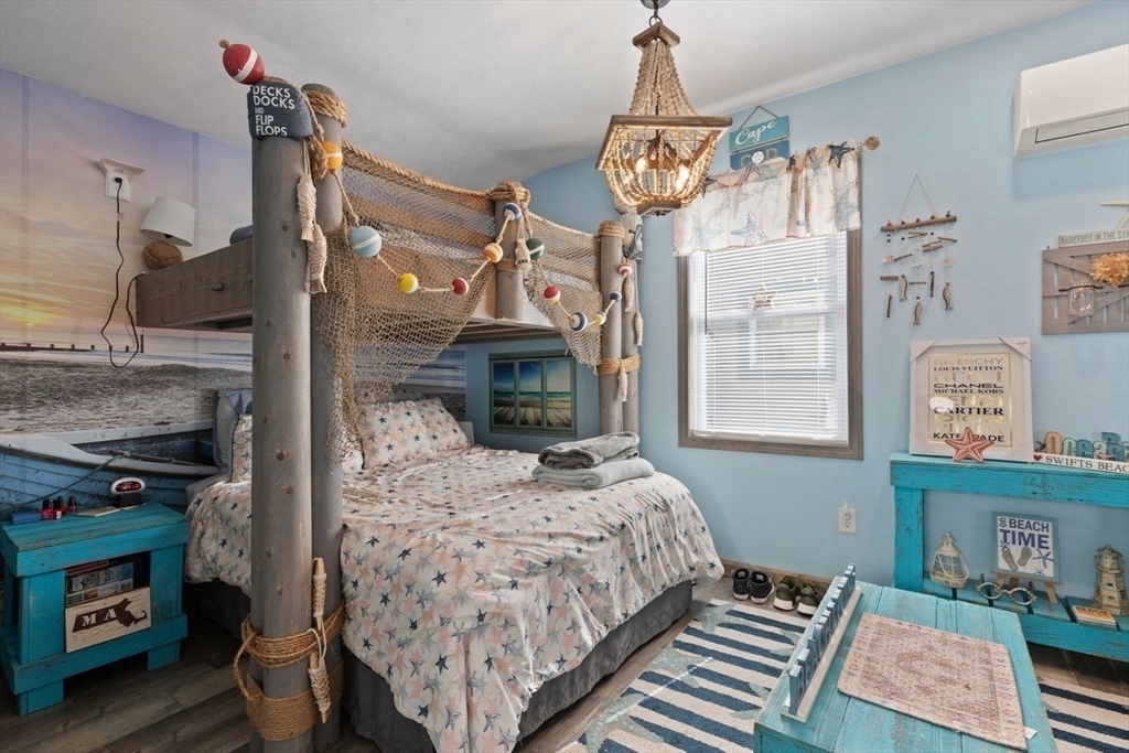 66 Bayview Street Wareham, MA 02571 - Photo 22 of 37 a bedroom with a bed a chandelier and a fireplace