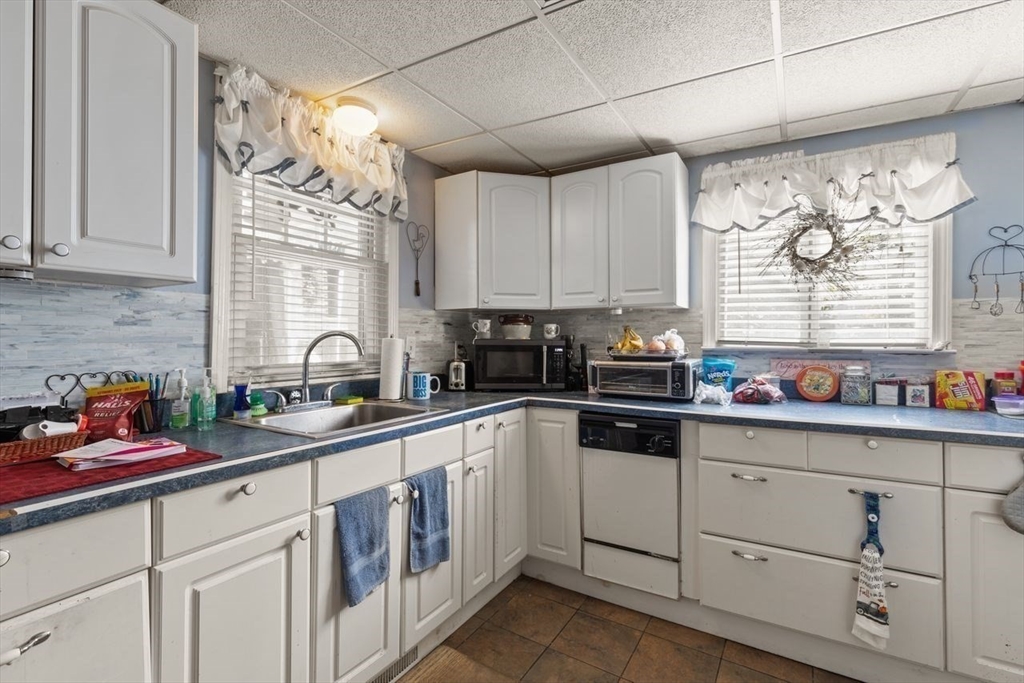 66 Bayview Street Wareham, MA 02571 - Photo 30 of 37 a kitchen with white cabinets a window and sink
