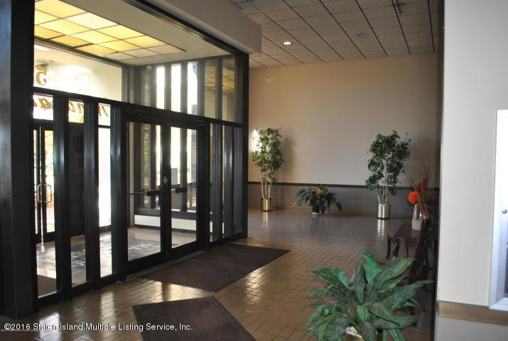 5 Windham Loop, Unit 1J Staten Island, NY 10314 - Photo 2 of 8 a hallway with a dining table and chairs