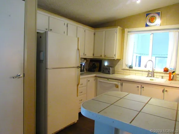 a kitchen with a refrigerator a sink and cabinets