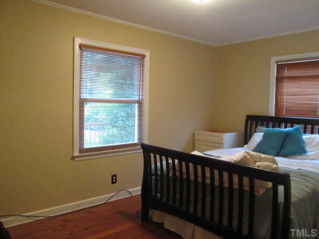 207 Plainview Avenue Raleigh, NC 27604 - Photo 16 of 25 Front bedroom with hardwoods, updated paint, smooth ceilings, crown molding, wood blinds and a nice closet for a home built during this time!