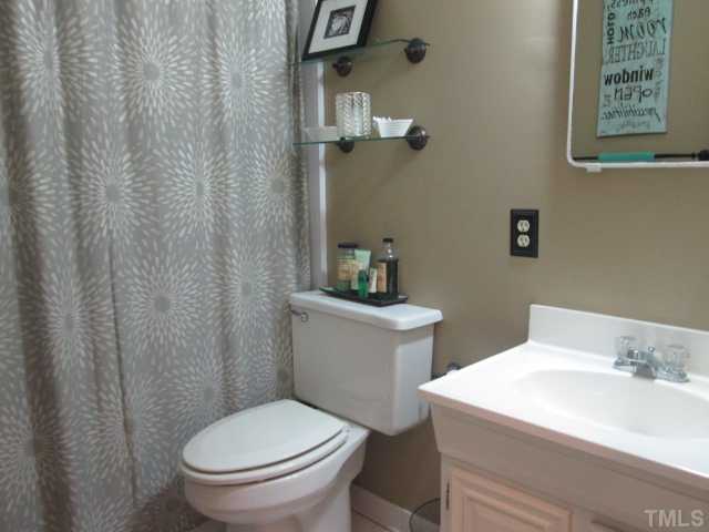 207 Plainview Avenue Raleigh, NC 27604 - Photo 17 of 25 Guest bath showing some updates that have been done through the years with elongated toilet, updated shower enclosure and more!