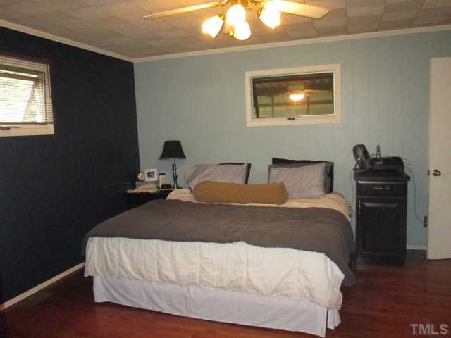 207 Plainview Avenue Raleigh, NC 27604 - Photo 19 of 25 Nice sized master suite with hardwoods, crank out windows, ceiling fan with light kit and a full master bath with updated vanity and tiled tube, shower! Crown molding as well! Very nice sized room!