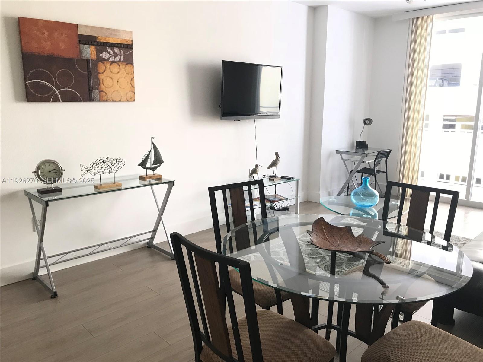 185 Southeast 14th Terrace, Unit 802 Miami, FL 33131 - Photo 12 of 19 a view of a dining room with furniture and a flat screen tv