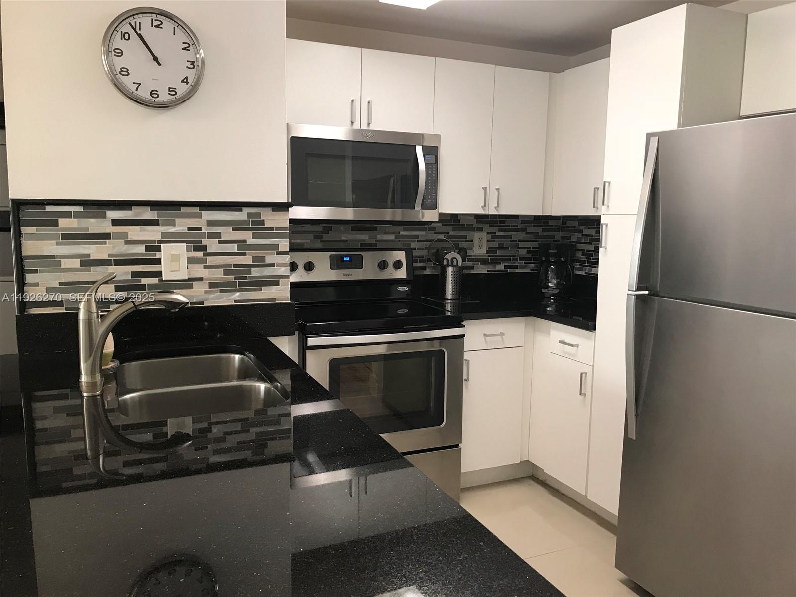 185 Southeast 14th Terrace, Unit 802 Miami, FL 33131 - Photo 8 of 19 a kitchen with a refrigerator and a stove top oven