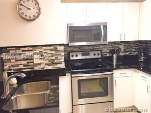 185 Southeast 14th Terrace, Unit 802 Miami, FL 33131 - Photo 10 of 19 a kitchen with a stove and a microwave