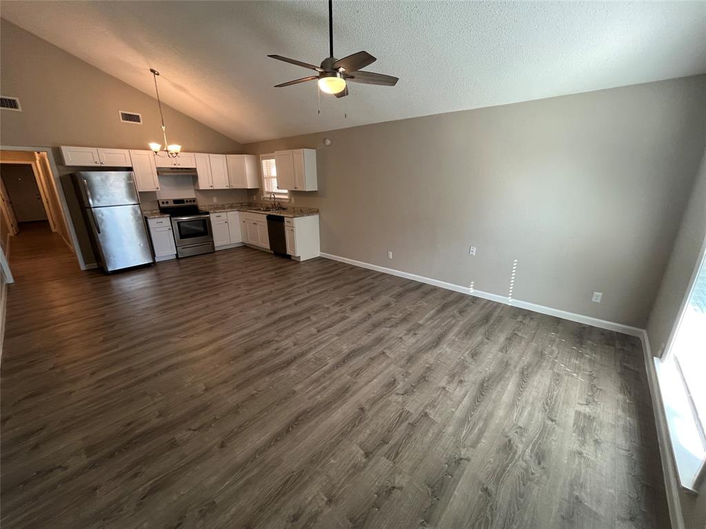 5827 Columbia Avenue Dallas, TX 75214 - Photo 15 of 15 an empty room with wooden floor kitchen view and a window