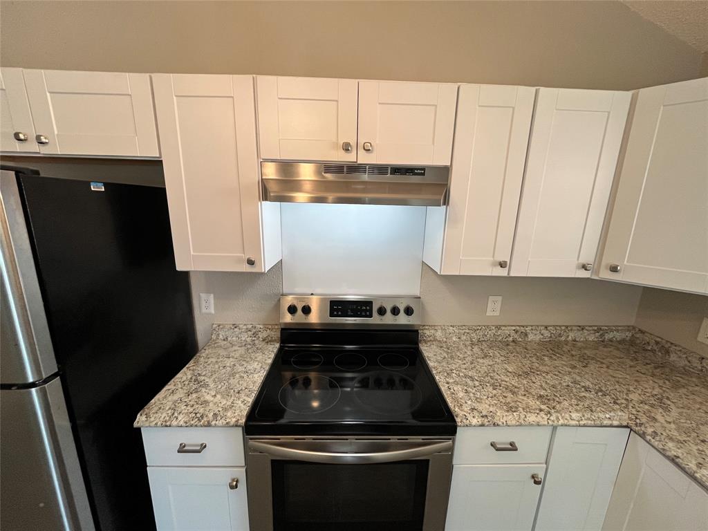 5827 Columbia Avenue Dallas, TX 75214 - Photo 5 of 15 a kitchen with granite countertop white cabinets and black appliances