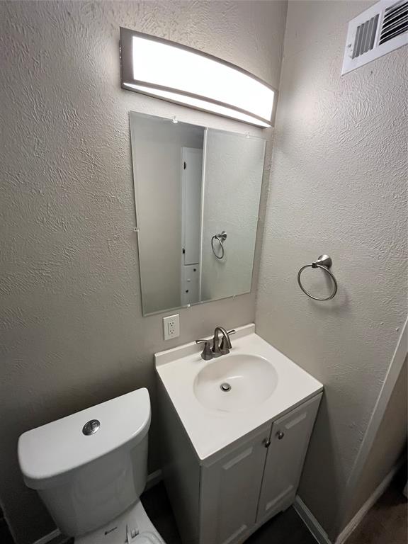 5827 Columbia Avenue Dallas, TX 75214 - Photo 9 of 15 a bathroom with a toilet a sink and mirror