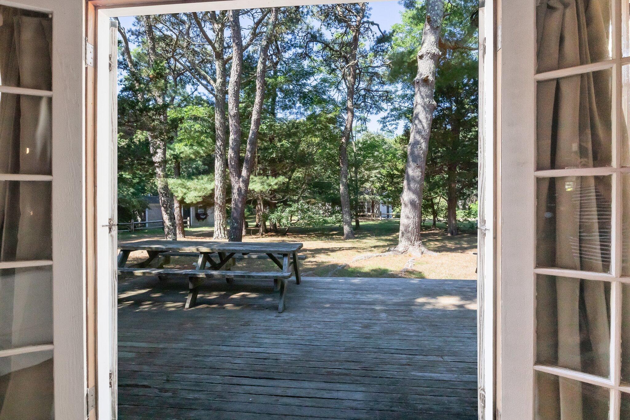 1975 State Highway, Unit 9 Eastham, MA 02642 - Photo 16 of 23 a view of backyard with a table and chairs and wooden fence