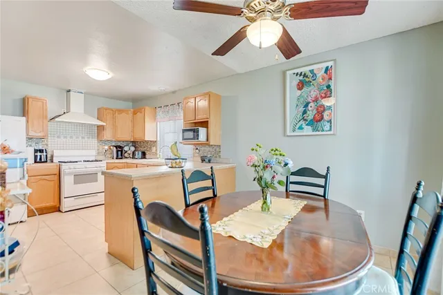 a dining room with furniture a kitchen view and wooden floor
