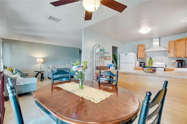 a dining room with wooden floor a chandelier a wooden table and chairs