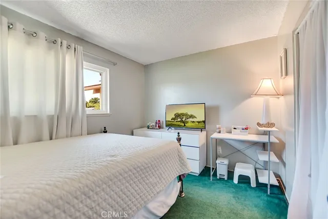 a bedroom with a bed painting on the wall and a potted plant